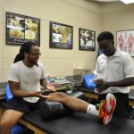 UCF RWC Athletic Trainer attends to a student at the Athletic Training clinic.